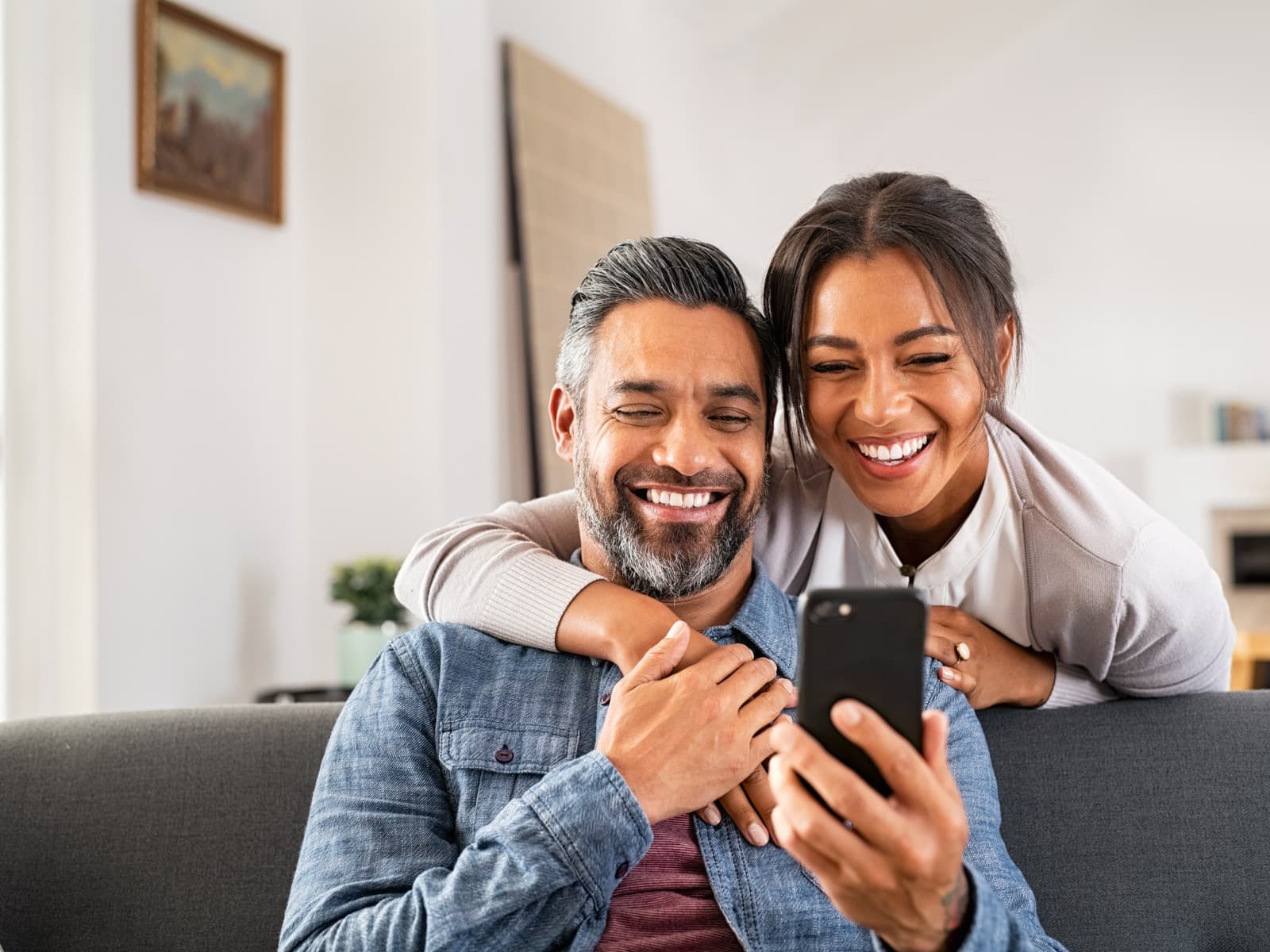 Couple taking a selfie in a sunny living room.